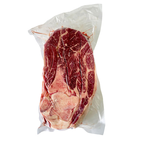 Vacuum-sealed package of raw beef on a white background