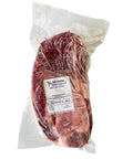 Raw steak in a vacuum-sealed package with a label on a white background