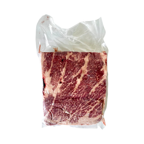 Packaged raw beef with marbling on a white background