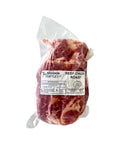 Raw beef chuck roast in a clear plastic bag with a label on a white background