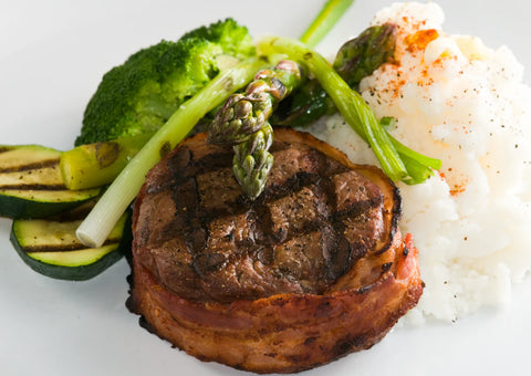 Grilled steak with vegetables and rice on a white plate