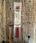 Packaged beef jerky sticks on a wooden surface