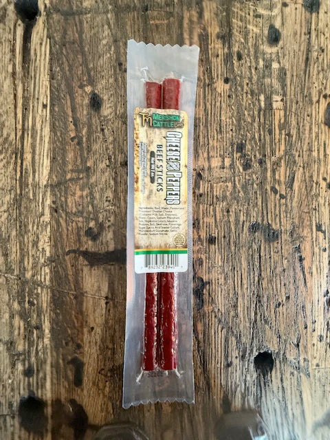 Packaged beef jerky sticks on a wooden surface