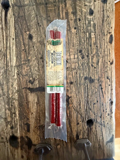 Packaged beef sticks on a wooden surface 
