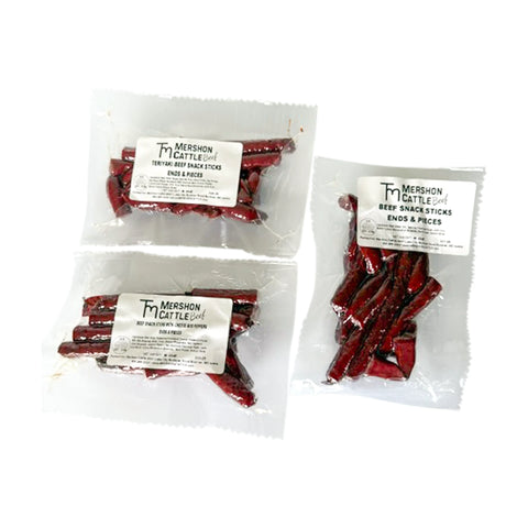 Three packages of beef snack sticks ends & pieces of varying flavors like original, teriyaki and cheese & peppers from Mershon Cattle on a white background