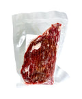 Vacuum-sealed package of raw meat on a white background