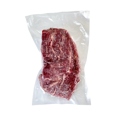 Vacuum-sealed raw steak on a white background