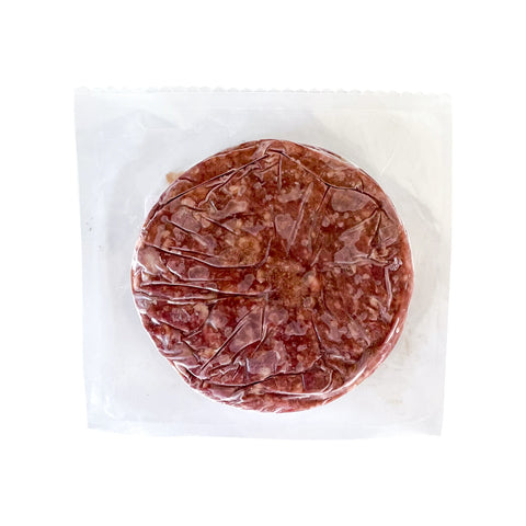 Round piece of raw meat in a clear plastic wrap on a white background