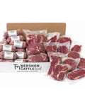 A Mershon Cattle Beef wholesale box filled with raw vacuum-sealed steaks, roasts, and ground meat, photographed on a white background.