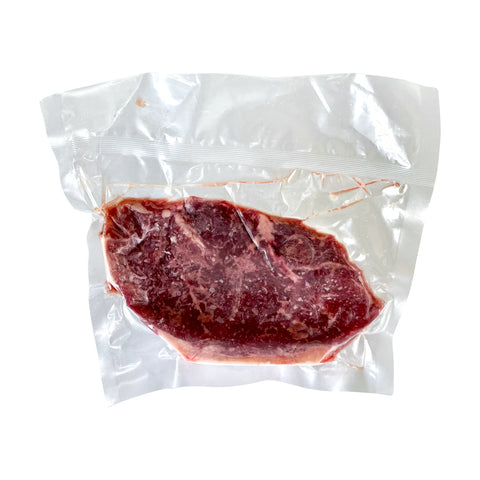 Vacuum-sealed raw steak on a white background