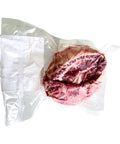 Vacuum-sealed package of raw meat on a white background