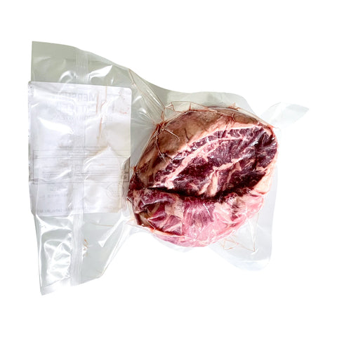Vacuum-sealed package of raw meat on a white background
