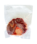 Vacuum-sealed raw steak on a white background