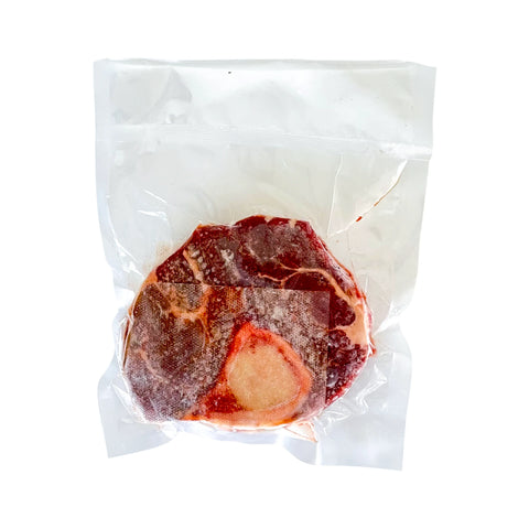 Vacuum-sealed raw steak on a white background