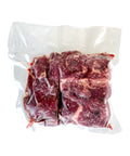 Vacuum-sealed package of raw beef on a white background