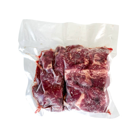 Vacuum-sealed package of raw beef on a white background