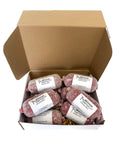 An open brown cardboard gift box containing several wrapped ground beef packages from Mershon Cattle Beef