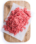 Ground beef on a wooden cutting board with white paper