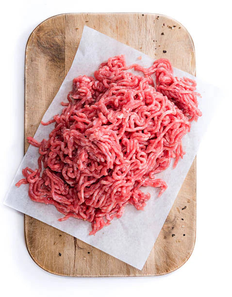 Ground beef on a wooden cutting board with white paper